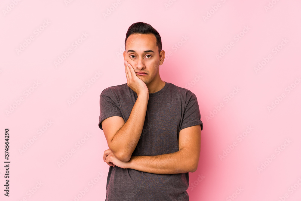 Yooung latin man posing in a pink backgroundwho is bored, fatigued and need a relax day. Yooung latin man posing in a pink backgroundwho is bored, fatigued and need a relax day.