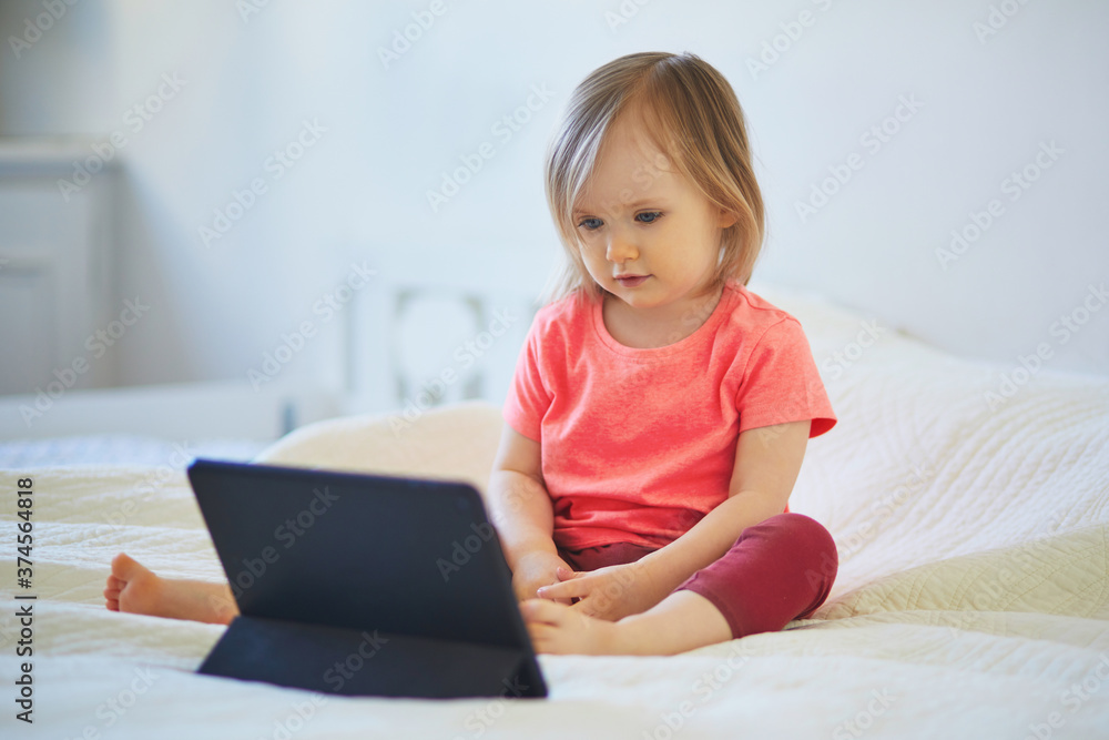 Toddler girl with digital tablet at home