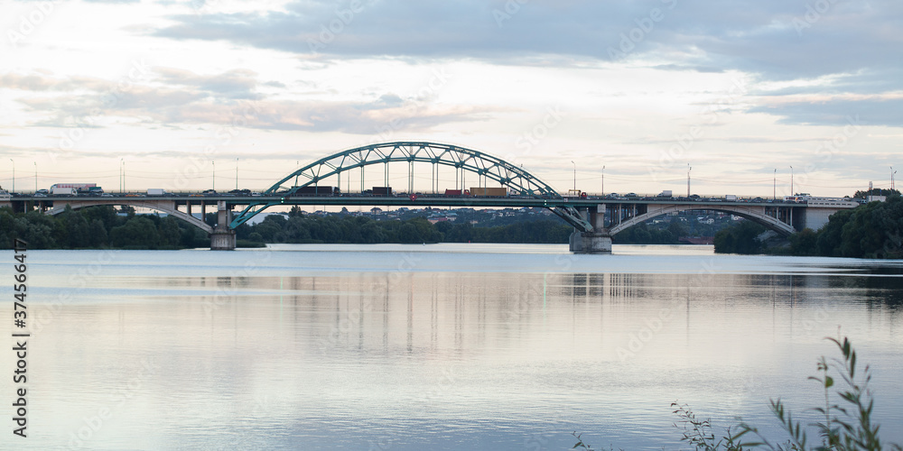 on a large modern bridge, cars cross a wide river