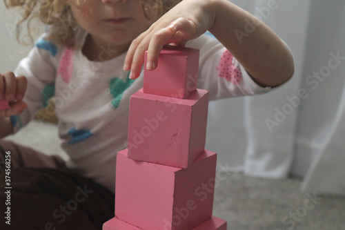 Child Assembling Montessori Pink Tower