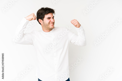 Young man isolated on white background raising fist after a victory, winner concept.