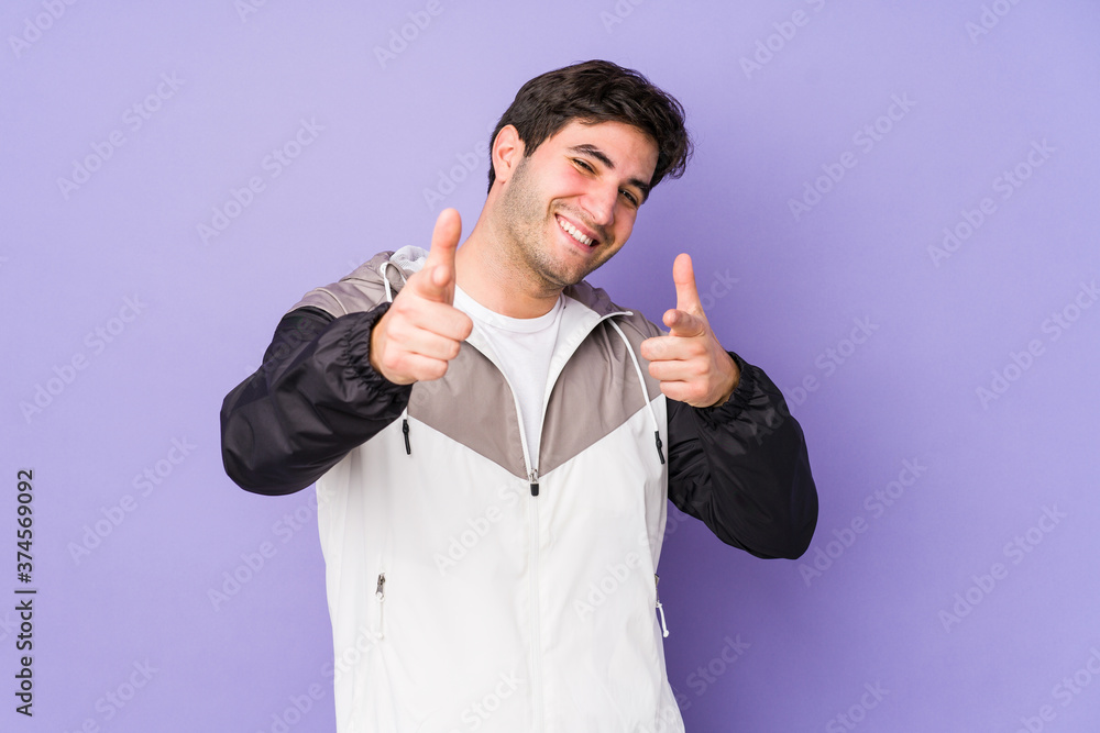 Young man isolated on purple background cheerful smiles pointing to front. Young man isolated on purple background cheerful smiles pointing to front.