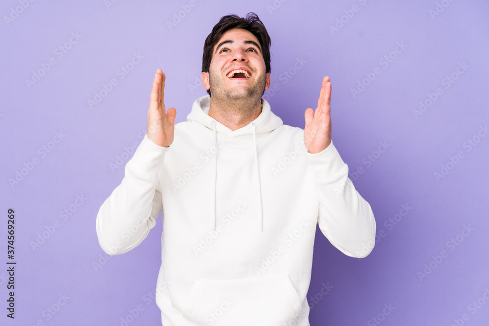 Young man isolated on purple background laughs out loudly keeping hand on chest. Young man isolated on purple background laughs out loudly keeping hand on chest.