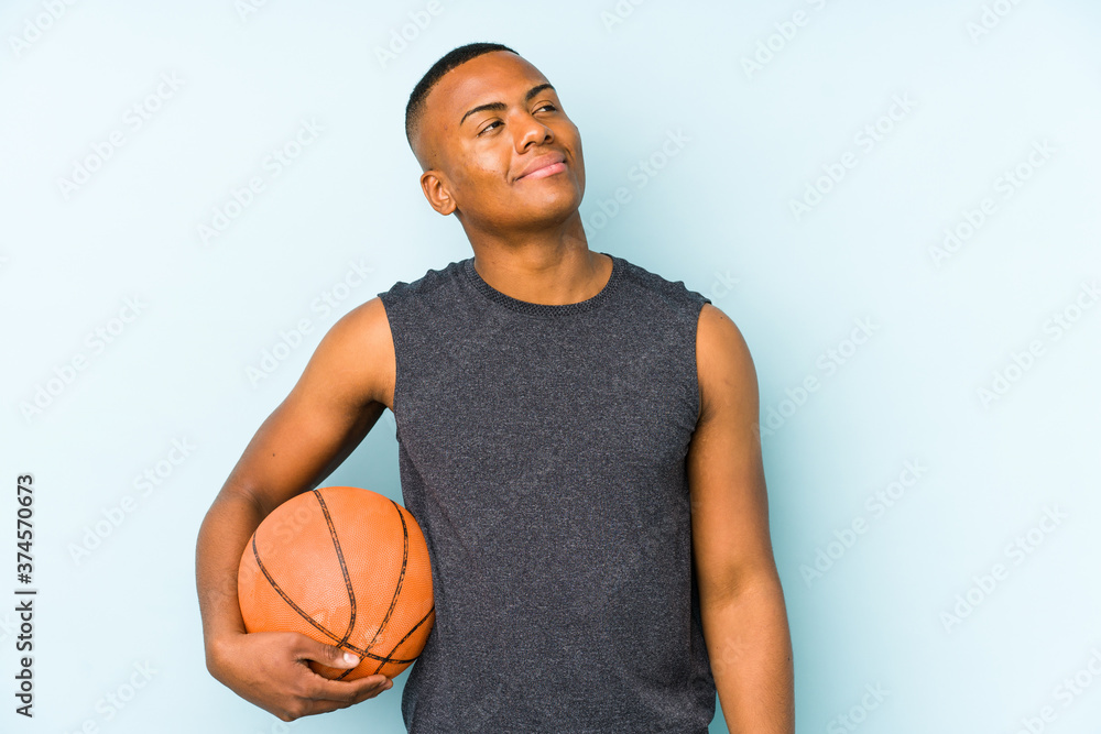 Young colombian man playing basketball isolated dreaming of achieving goals and purposes Young colombian man playing basketball isolated dreaming of achieving goals and purposes