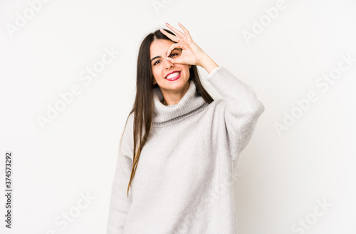 Young caucasian woman isolated on a white background excited keeping ok gesture on eye.