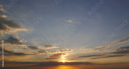 Sunrise sky and sun through the clouds over. Golden sunrise with blue colors. © Марина Миколута