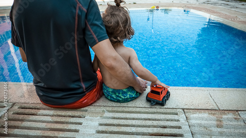 Εκτύπωση καμβά A father is surveilling his son at the swimming pool to prevent accidents
