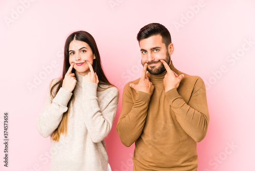 Young caucasian couple isolated doubting between two options.