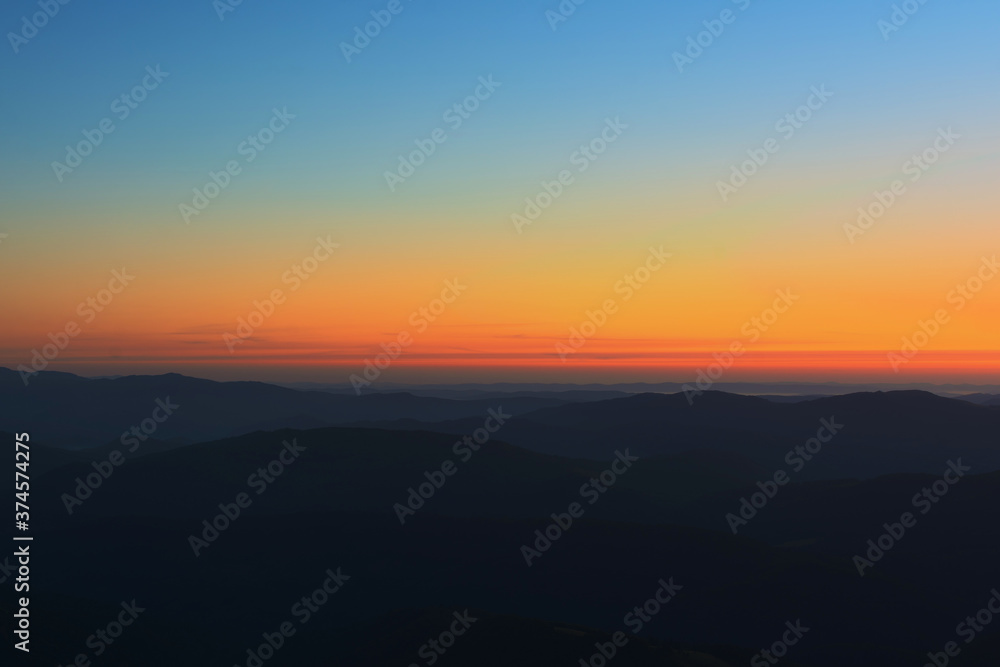 The first or last rays of the sun on a mountain pass. Morning and evening in nature. Colorful sunset and sunrise over the mountain hills. Carpathians in summer and autumn. The first or last rays of the sun on a mountain pass. Morning and evening in nature. Colorful sunset and sunrise over the mountain hills. Carpathians in summer and autumn.