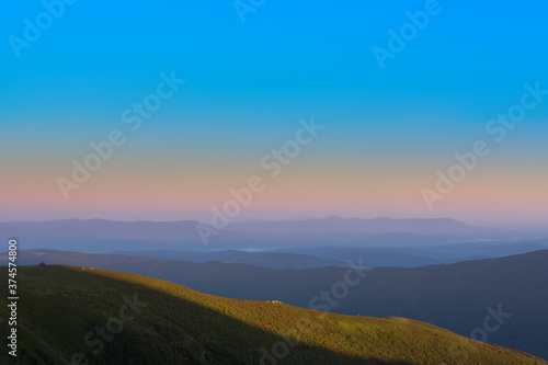 The first or last rays of the sun on a mountain pass. Morning and evening in nature. Colorful sunset and sunrise over the mountain hills. Carpathians in summer and autumn. © Mykhailo Abramov