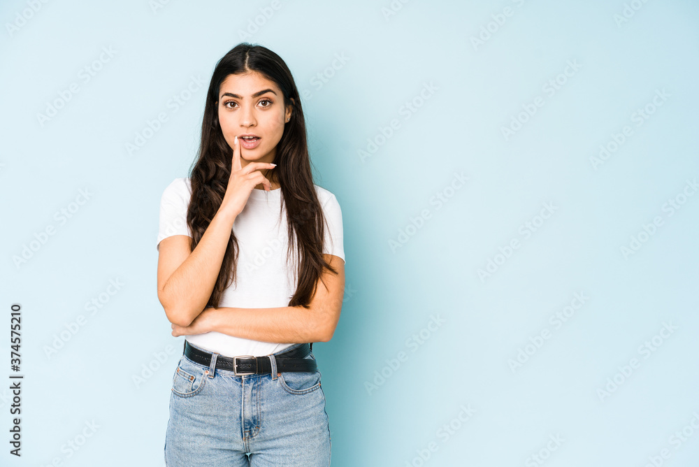 Young indian woman on blue background having some great idea, concept of creativity. Young indian woman on blue background having some great idea, concept of creativity.