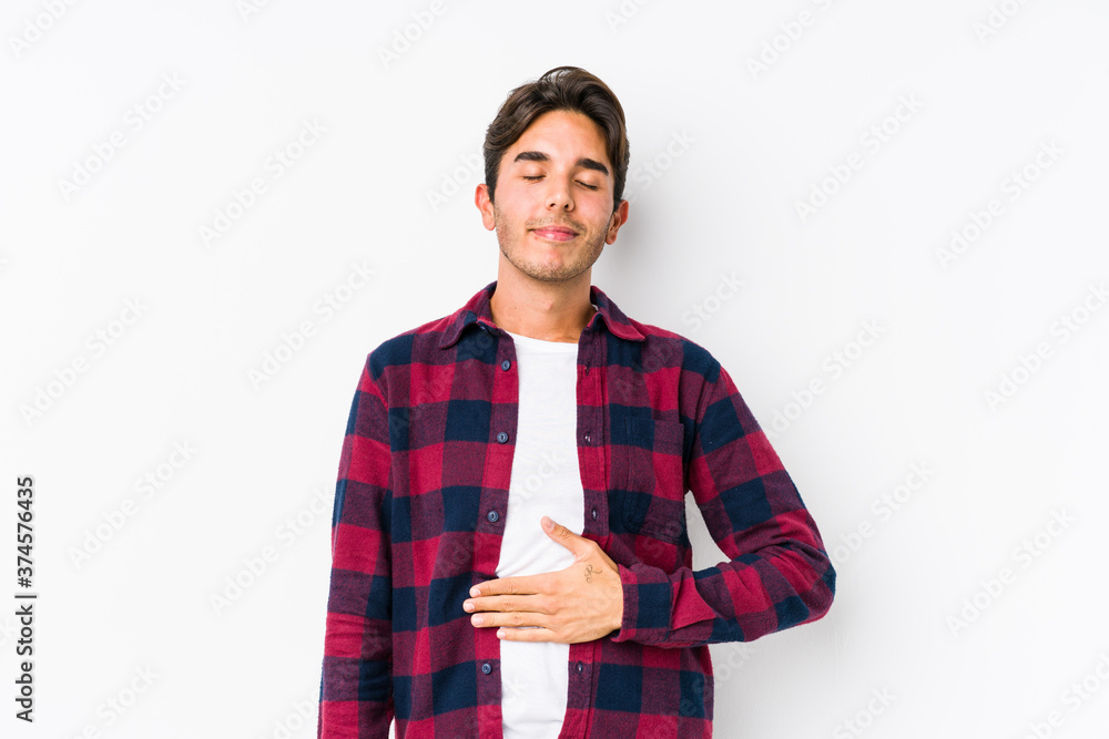 Young caucasian man posing in a pink background isolated touches tummy, smiles gently, eating and satisfaction concept. Young caucasian man posing in a pink background isolated touches tummy, smiles gently, eating and satisfaction concept.