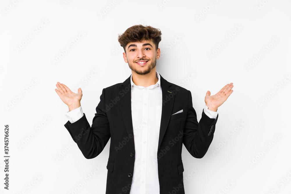 Young arabian business man isolated makes scale with arms, feels happy and confident. Young arabian business man isolated makes scale with arms, feels happy and confident.