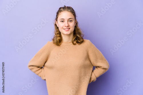 Young caucasian woman on purple background happy, smiling and cheerful.