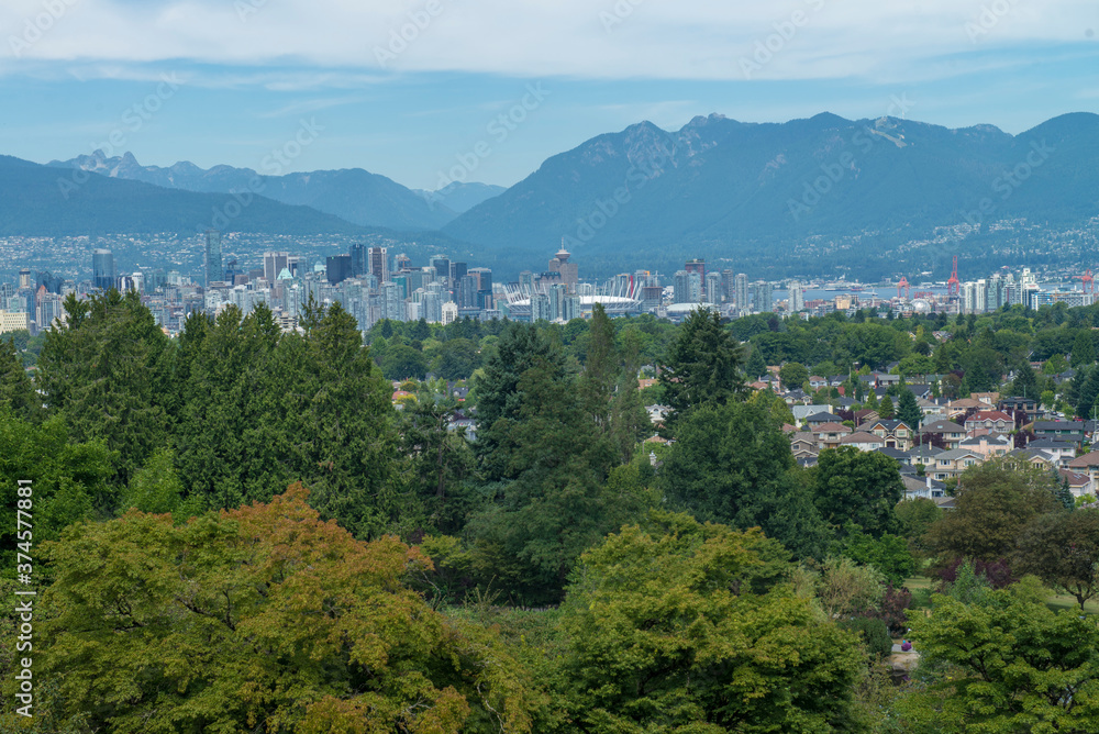 A view of the city of Vancouver between trees and mountains in a summer morning, British Columbia. Canada