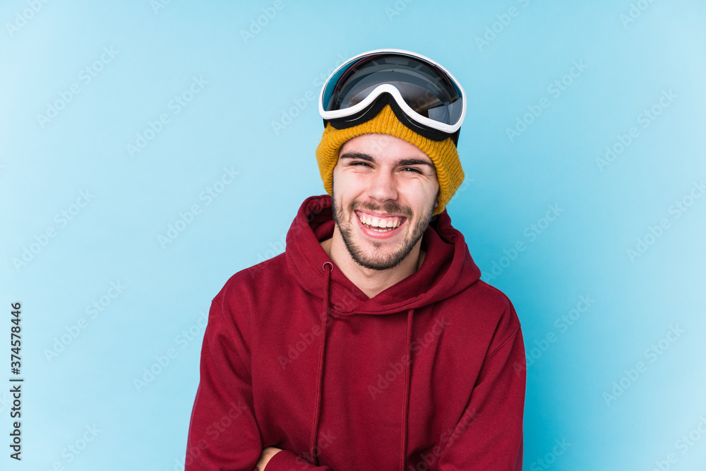 Fototapeta premium Young caucasian man wearing a ski clothes isolated laughing and having fun.