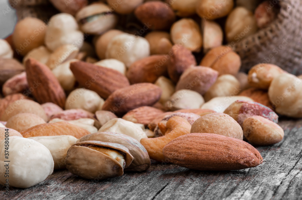 Mixed Nuts, dried fruits on wooden table, different kind of healthy food. Walnut, hazelnut, pistachio, cashew, peanut, almond Mixed Nuts, dried fruits on wooden table, different kind of healthy food. Walnut, hazelnut, pistachio, cashew, peanut, almond
