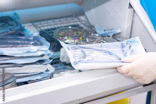 nurse doing sterilization of dental medical instruments in autoclave. Sterilization department at dental clinic