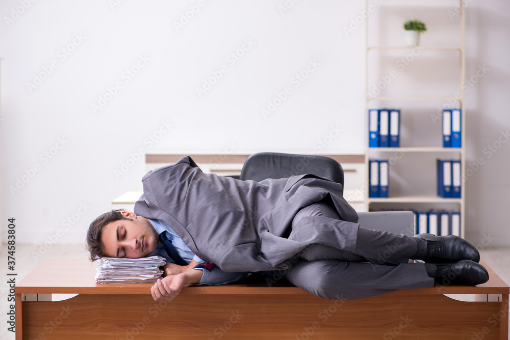Young male employee sleeping in the office Young male employee sleeping in the office