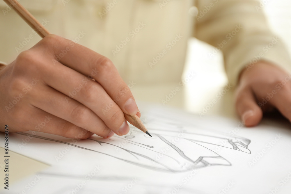 Woman drawing clothes with pencil on sheet of paper at white table, closeup Woman drawing clothes with pencil on sheet of paper at white table, closeup