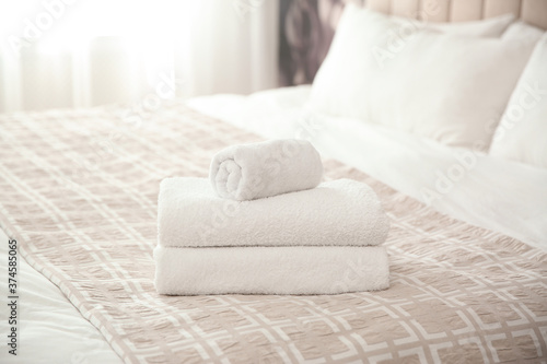 Clean white towels on bed at home