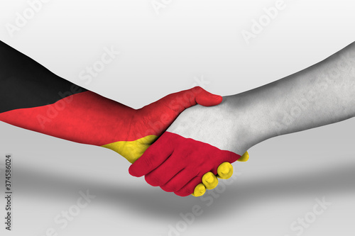 Handshake between poland and germany flags painted on hands, illustration with clipping path.