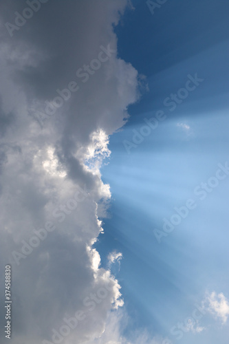  heavenly light rays passing through clouds in blue sky