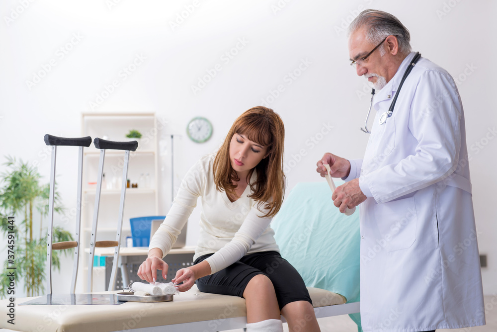 Obraz premium Young injured woman visiting experienced doctor traumatologist