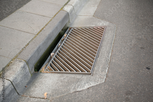 Gutter of a stormwater drainage system in perspective on the side of an road with markings. Australia. Melbourne. 