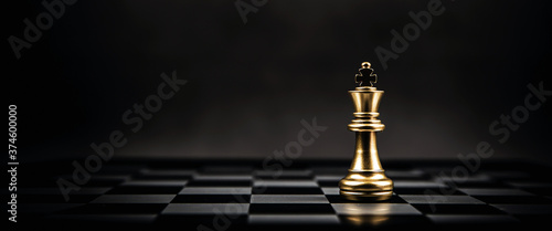 King golden chess standing on chess board concept of business strategic plan and professional organization management leader.