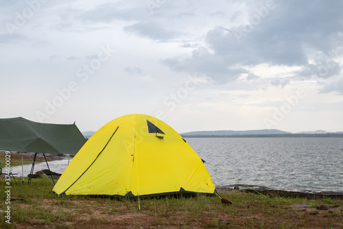 Camping on the island, Yellow tent on the shore by the sea. © Maxky