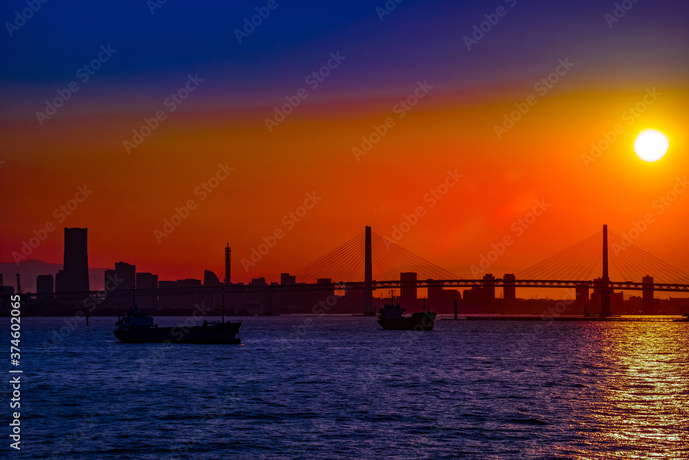 貨物船のシルエットと横浜の街並みの夕景