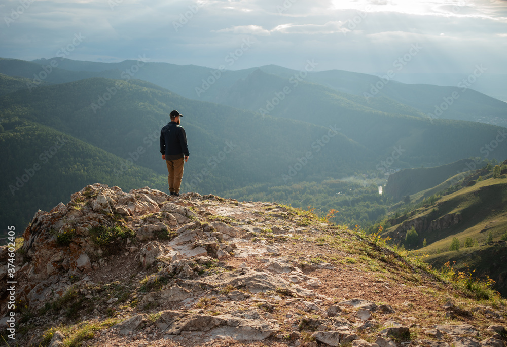 Obraz premium The traveler on the top of the mountain looks into the distance