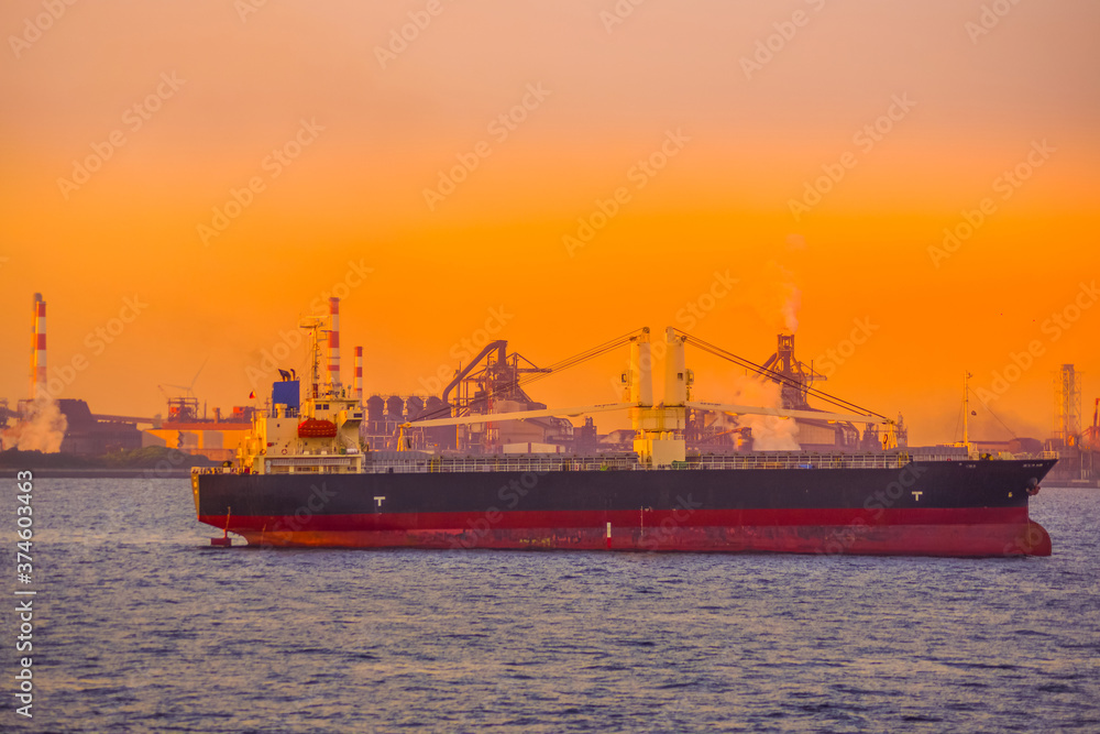 Fototapeta premium 貨物船のシルエットと夕景