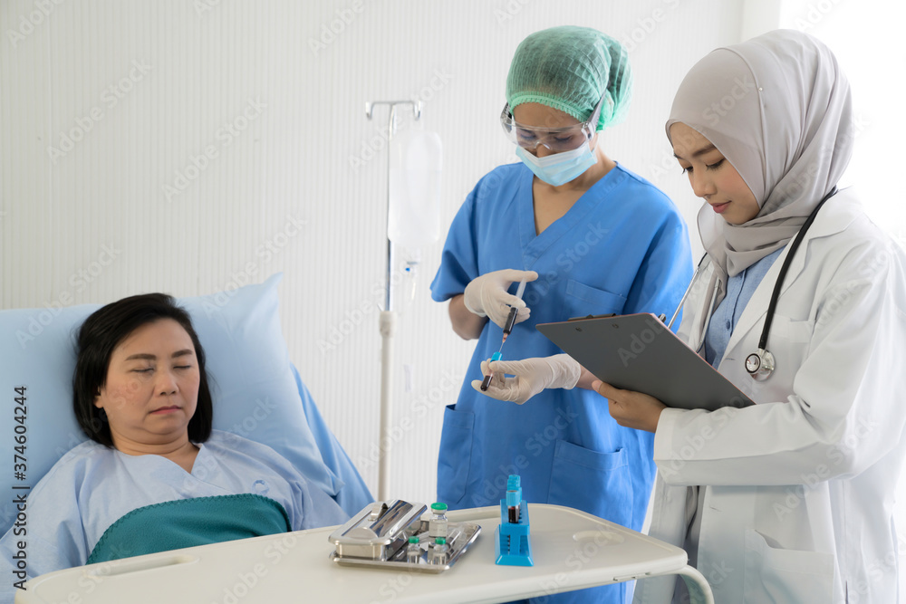 Obraz premium Asian female doctor wearing protective gears examination and treating patient in a hospital room