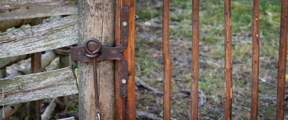 100 years old wrought iron lock on a handmade wooden fence
