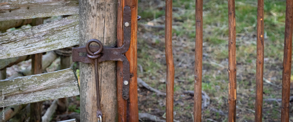 100 years old wrought iron lock on a handmade wooden fence 100 years old wrought iron lock on a handmade wooden fence