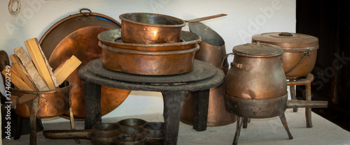100 years old copper and cast iron kitchenware on a wood fired stove. Still life
