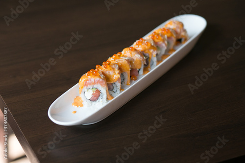 California salmon sushi rolls stuffed with salmon, avocado, topping salmon roe and spicy cream sauce. Japanese food style