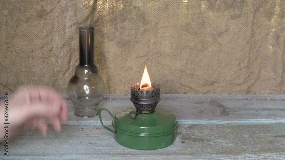 Man lights a kerosene lamp. Retro, old theme.