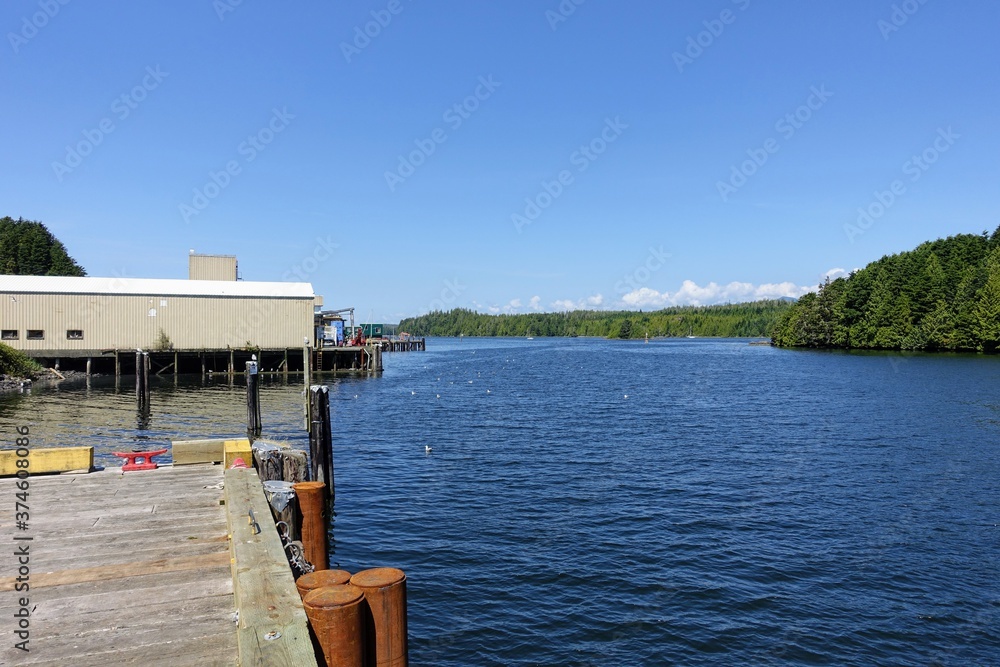A view of the waterfront and pier on the inside facing part of Ucluelet, with a view of the ocean inlet on a pretty sunny summer day