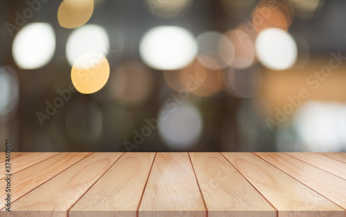 Empty wooden table top with lights bokeh on blur restaurant background