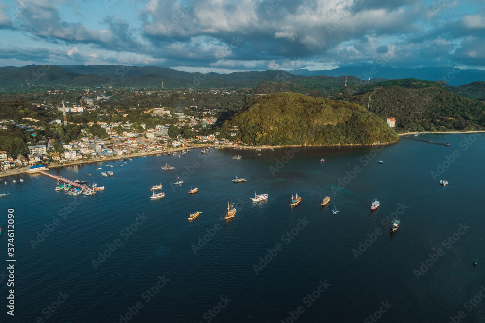 parking of ships.city port.Wild islands of Indonesia. Flores tropical paradise. Labuan Bajo. drone shooting. Wild beaches, blue logons, coral reefs, green hills. aerial view. boat trip safari. harbor 