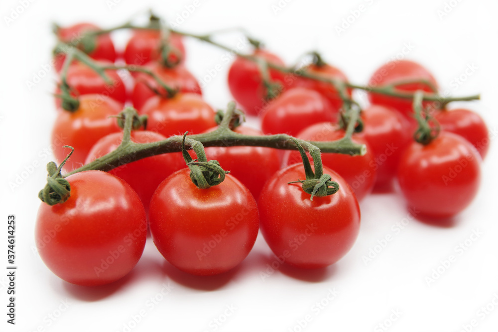 Cherry tomatoes isolated on a white background. Red tomatoes on a twig Cherry tomatoes isolated on a white background. Red tomatoes on a twig