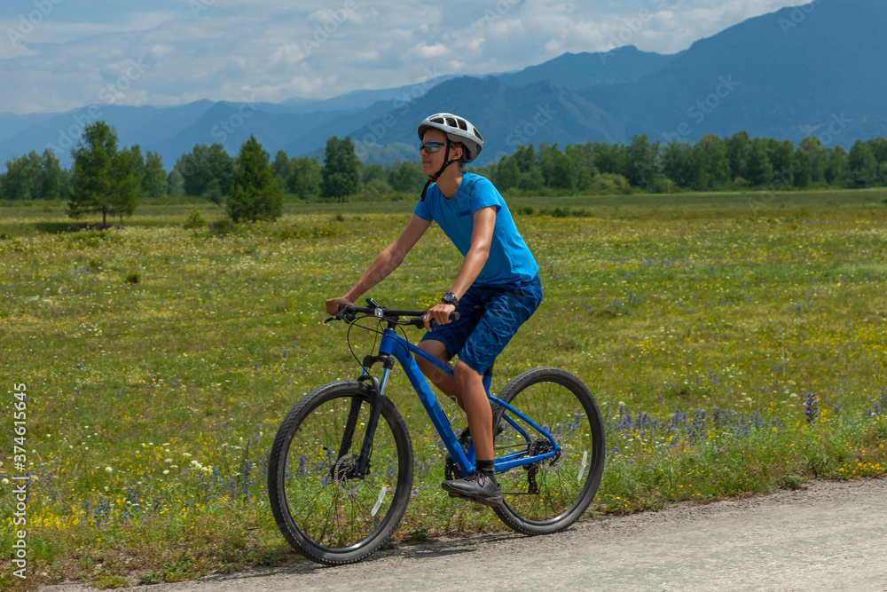 A young man on a mountain bike travels through the picturesque places of the Altai mountains.