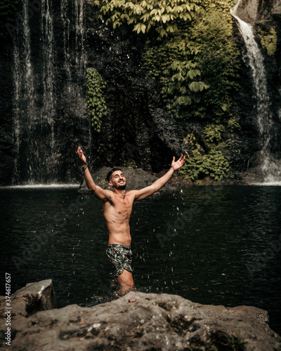 Male model in a waterfall in Bali Indonesia