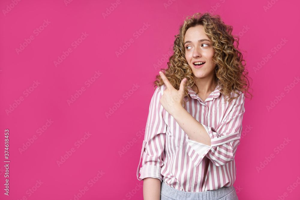 Young beautiful woman shows her finger to the left. Young beautiful woman shows her finger to the left.