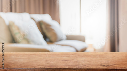 Empty wood table top and blurred living room in home interior with curtain window background. - can used for display or montage your products.