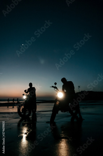 Two custom motorbikes at the beach during sunset  in Bali Indonesia