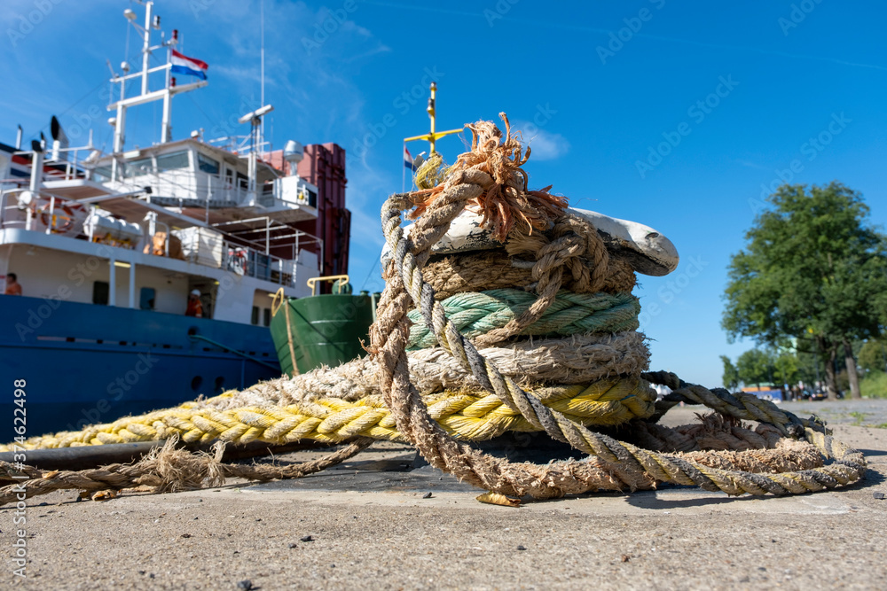 Obraz premium Thick ropes wrapped around a mooring post